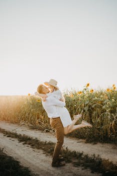 日落时分，一对相爱的夫妇在充满活力的向日葵田中浪漫相拥