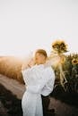 Woman in White Long Sleeve Shirt Holding Sunflower