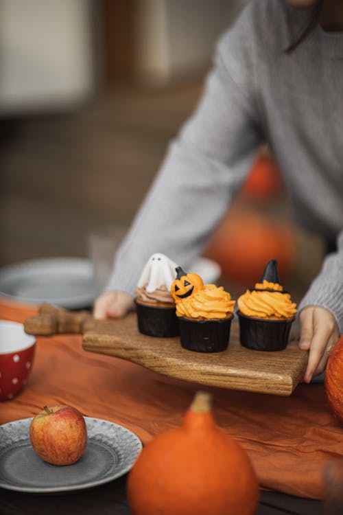 Free Person Holding Brown Wooden Chopping Board With Cupcakes Stock Photo