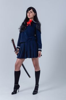 一位身着日本女学生服装的女子，手持武士刀，自信地散发着优雅与力量