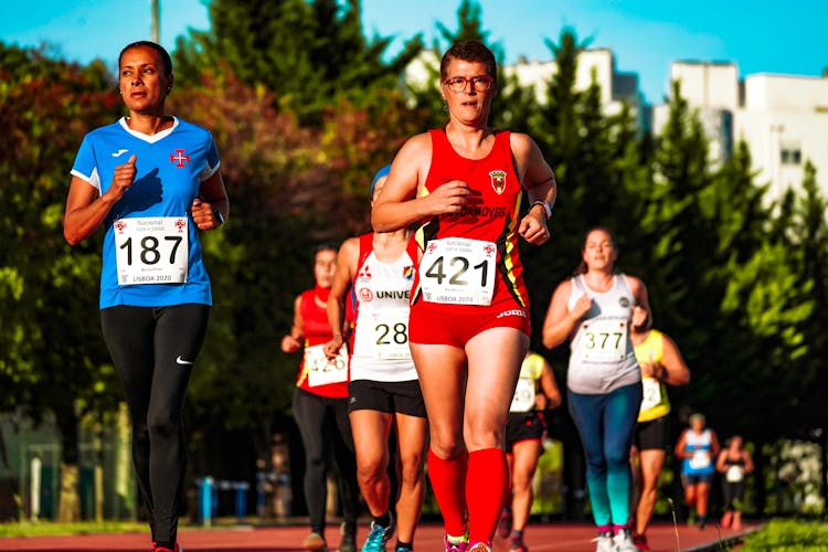 Female Athletes Running On Race Track In Stadium