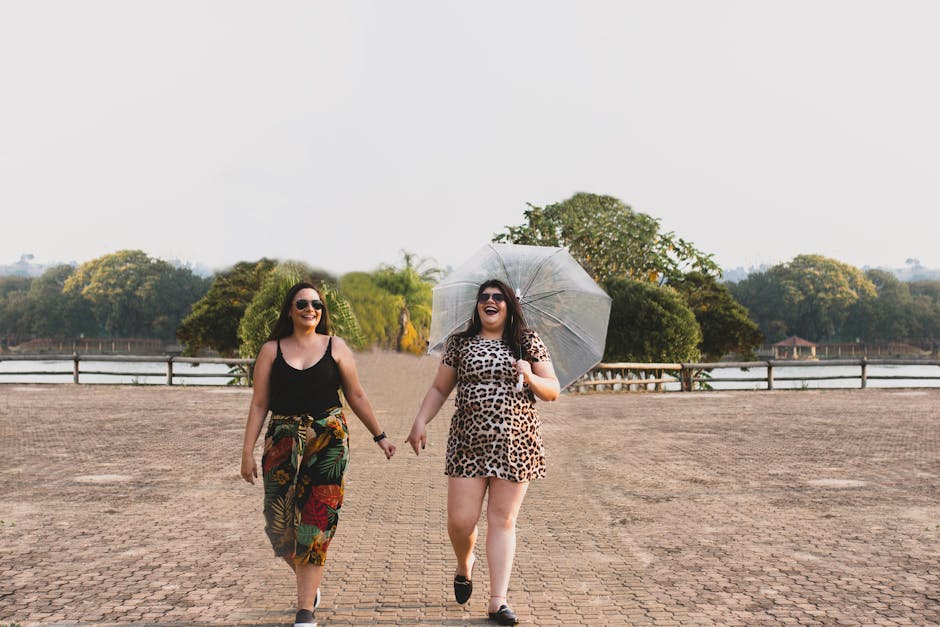 6 Dicas para Cultivar a Amizade Feminina com Leveza 2 Two women enjoying a sunny day while walking with an umbrella in Santa Cruz da Conceição, Brazil.