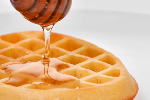 Close-up Shot of a Waffle with Honey