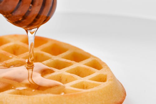 Close-up Shot of a Waffle with Honey