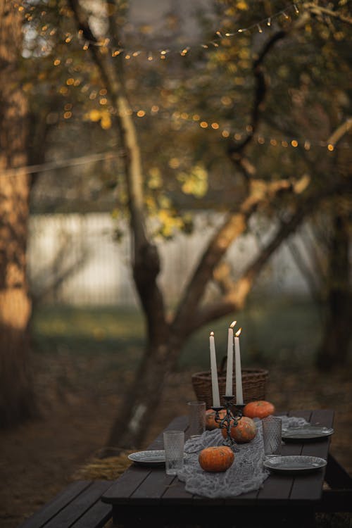 Halloween Table Setting With Lighted Candles And Pumpkins