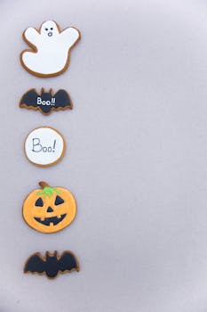 Halloween-themed cookies featuring ghost, bats, and pumpkin shapes with copy space.