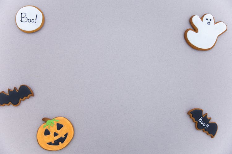 Various Halloween Gingerbread Cookies Placed On Gray Background