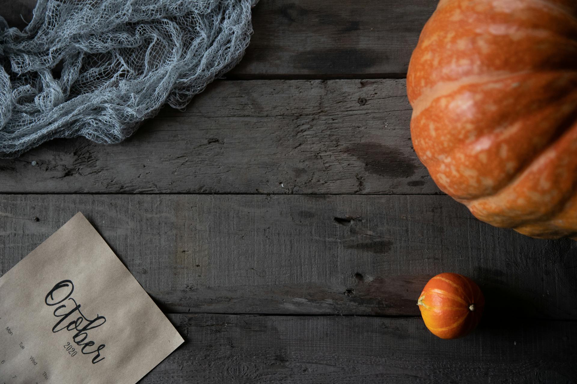 Pumpkin Beside A Gray Yarn on Brown Wooden Table