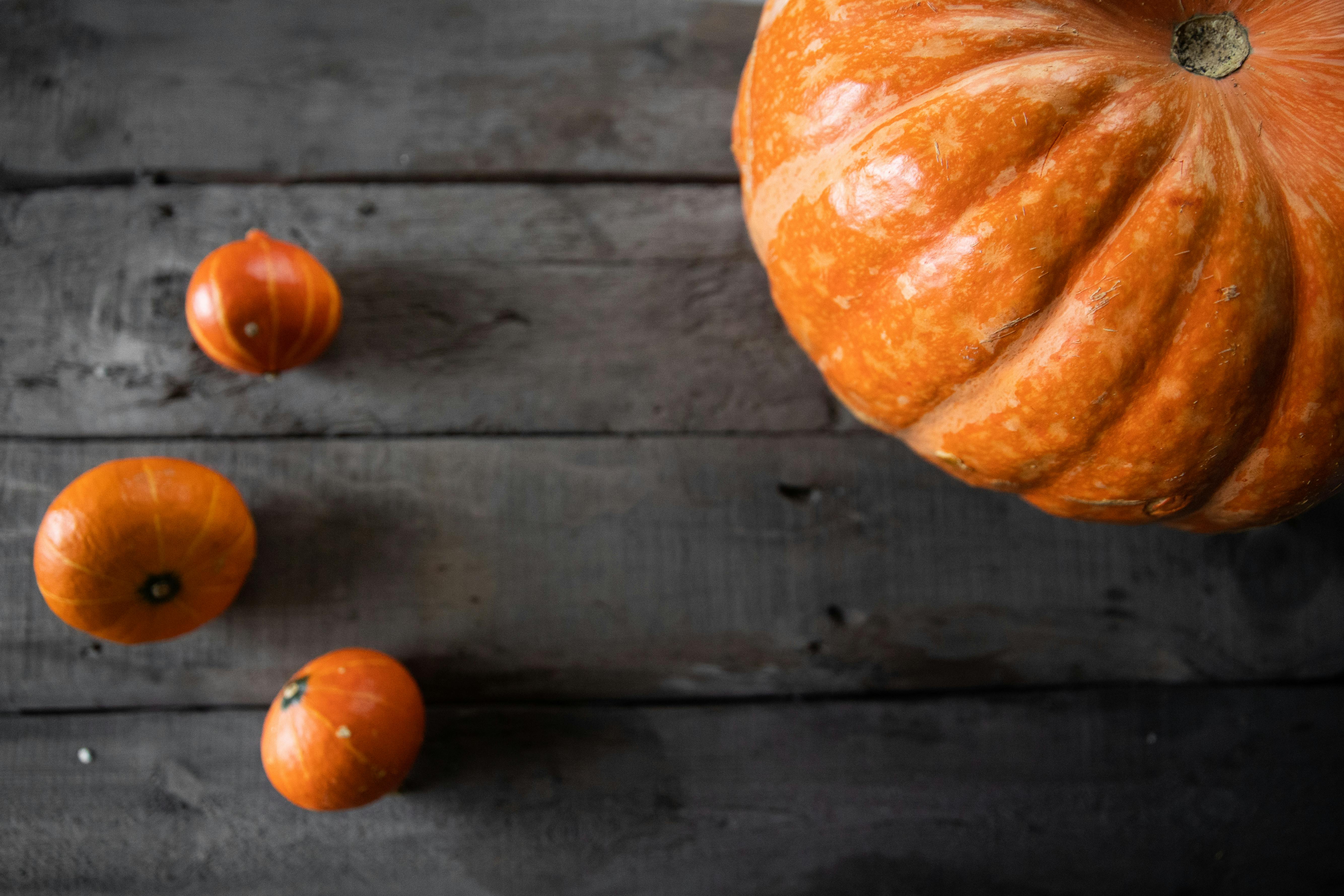 orange pumpkins on brown wooden table