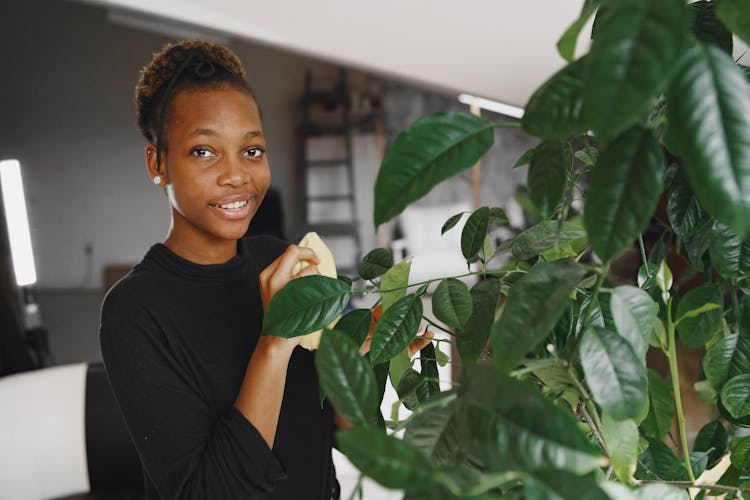 Woman Standing Near The Indoor Green Plant