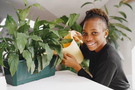 Girl Watering a Potted Plant and Smiling