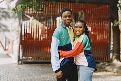 Free An African couple smiling and embracing in a vibrant urban setting. Stock Photo
