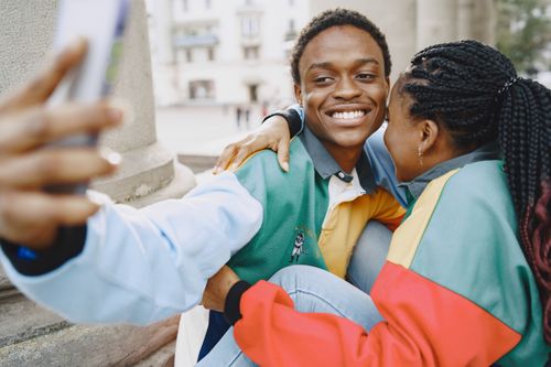 Free Happy couple taking a selfie, embracing and smiling in an outdoor setting. Stock Photo