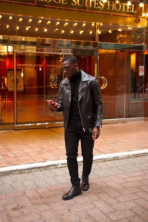 Man in Black Leather Jacket Using Smartphone