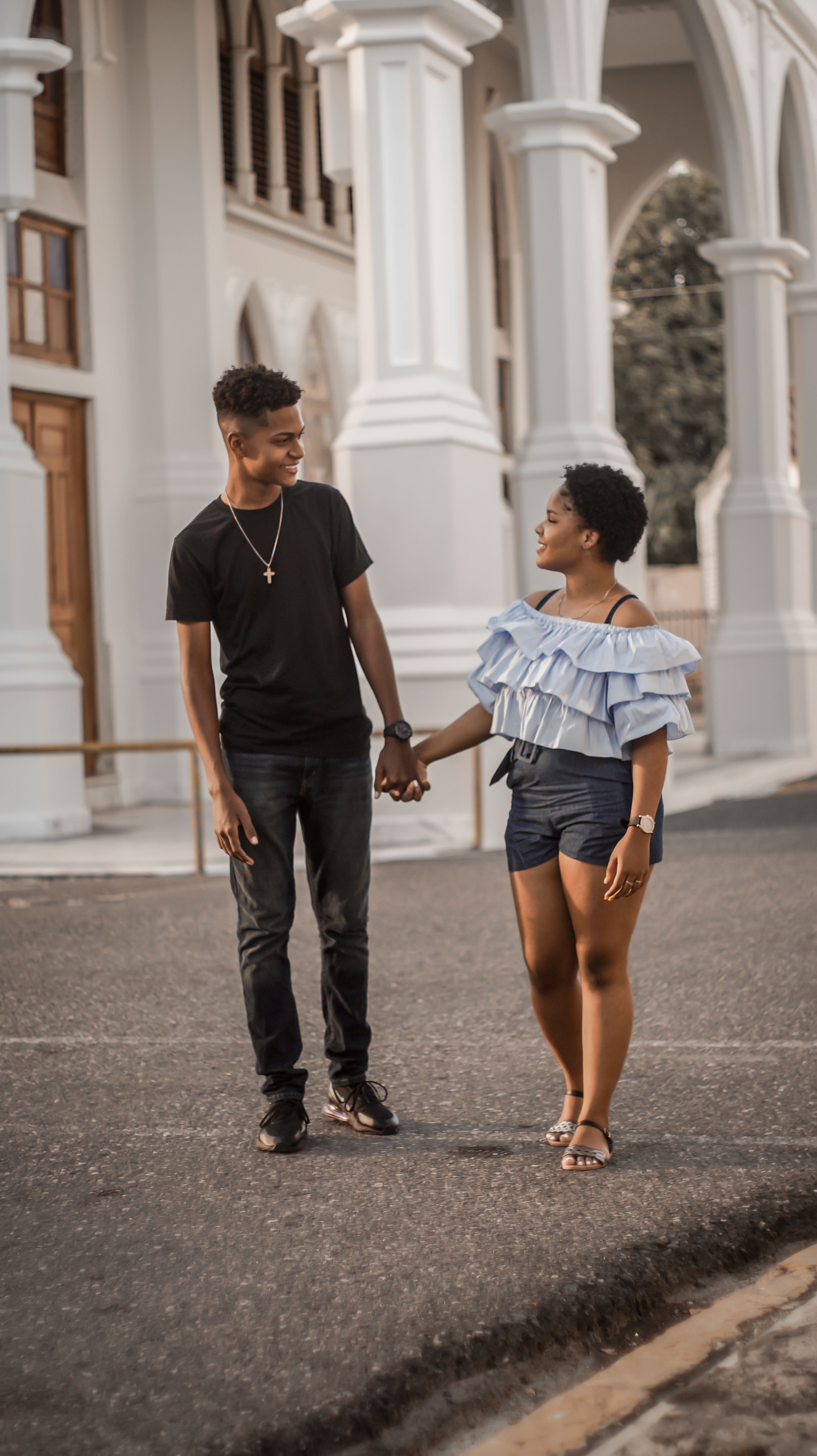 A happy couple holding hands and walking, Dominican Republic street scene.