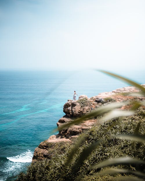 Woman with Open Arms Standing on the Mountain Cliff