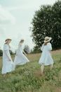 Women in White Clothes Walking on Green Grass Field