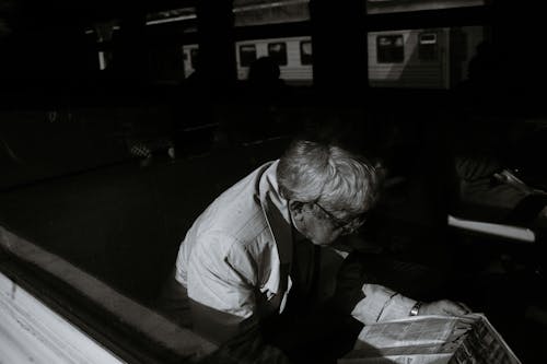 Monochrome Photo of Man Reading a Newspaper