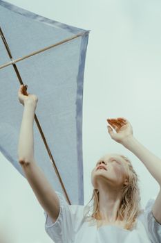 在明亮的夏日天空下，一位白人妇女正享受放风筝的乐趣，这非常适合生活方式和休闲概念