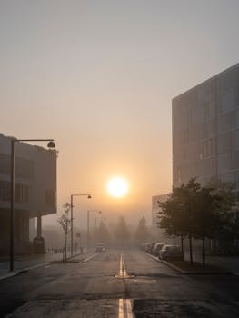 Serene sunrise over a quiet, misty street in Copenhagen, Denmark, capturing urban beauty.