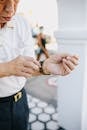 Man in White Dress Shirt Holding Fixing His Watch