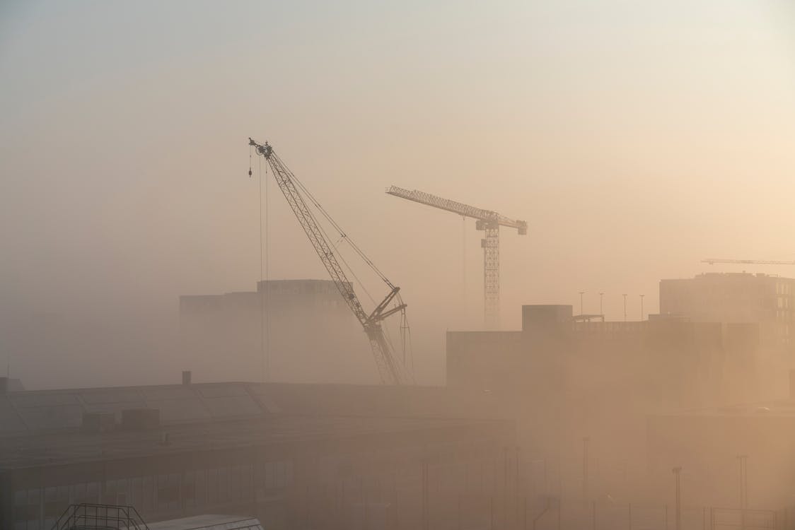 Free Cranes Near Building during Sunset Stock Photo