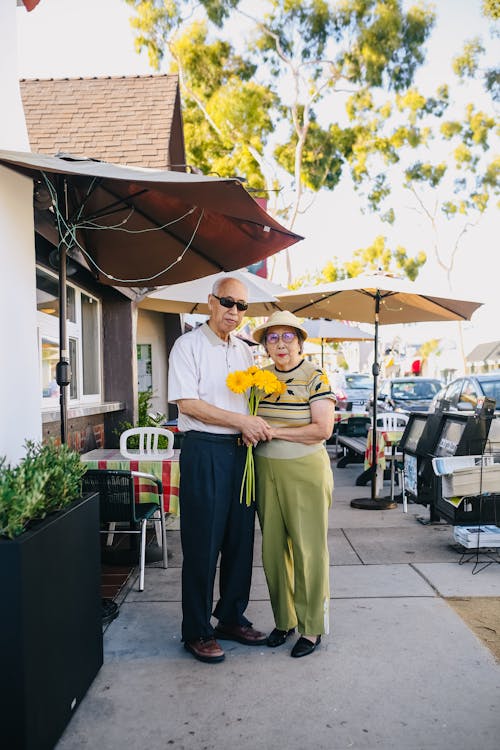 Elderly Couple Holding Bouquet of Flowers while Holding Hands