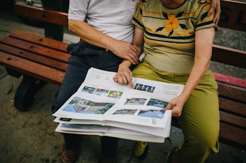 Free Elderly Couple Sitting on Wooden Bench Stock Photo