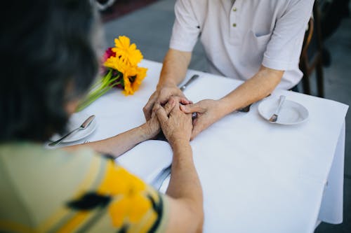 Bejaarde Echtpaar Hand In Hand Op De Tafel