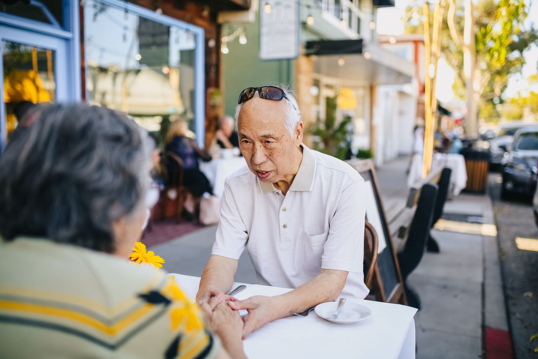 Couple senior partageant une conversation animée en terrasse.