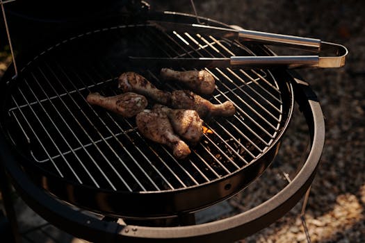Juicy chicken drumsticks grilling on an outdoor barbecue, perfect for a summer cookout.