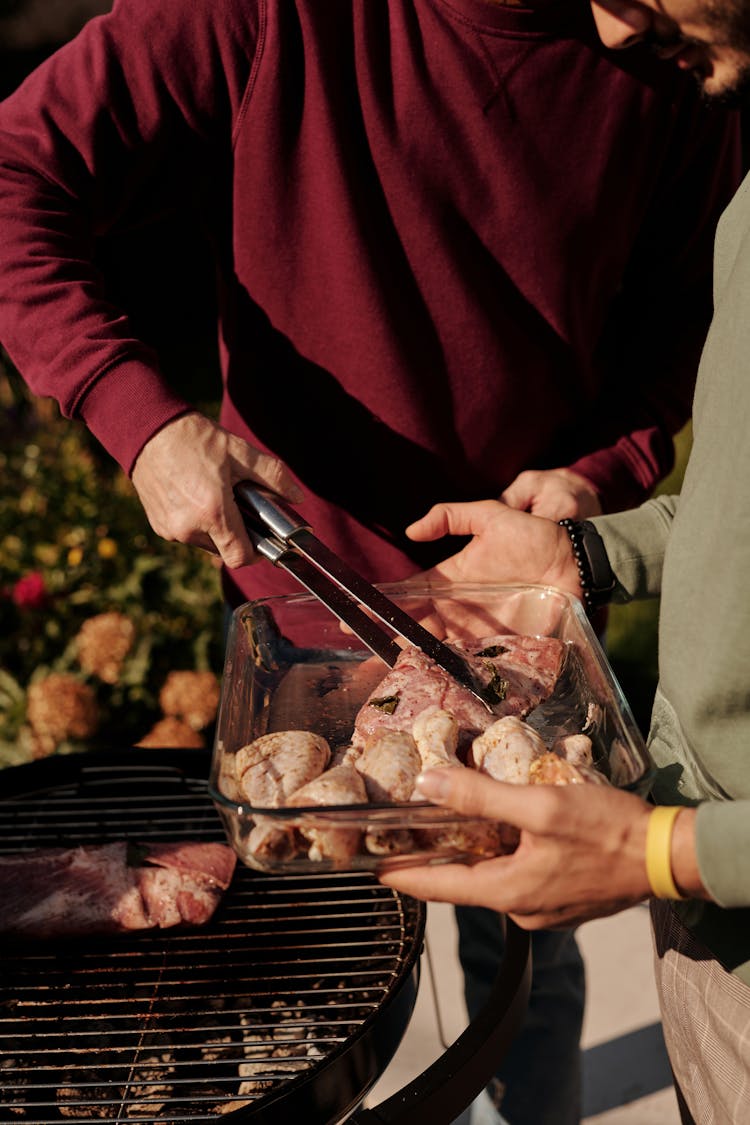 Close-Up Shot Of A Person Grilling Chicken