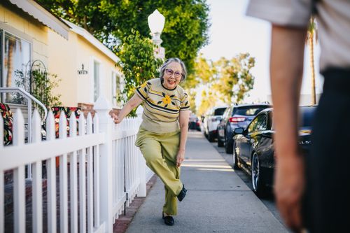 Free Happy senior woman having fun on a sunny day in a suburban street. Stock Photo