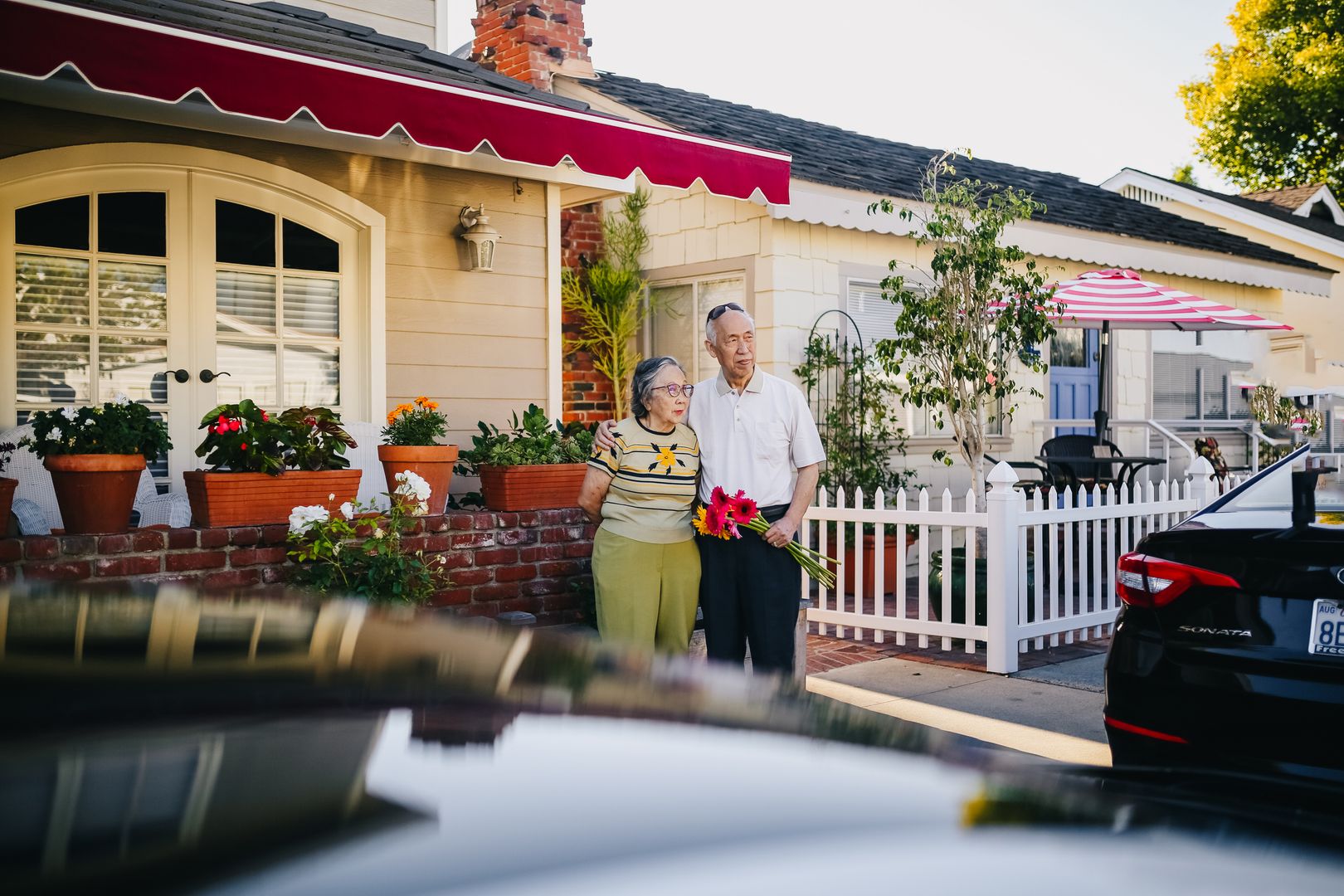 Elderly couple standing together outside their home
