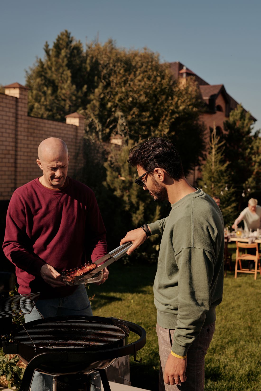 Two Men Grilling Meat Together