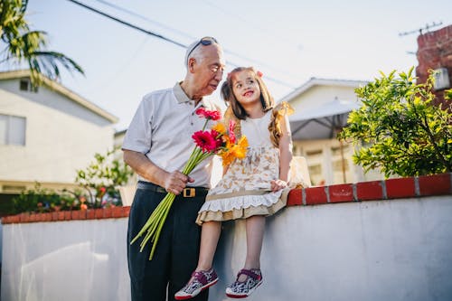 Old Man Holding Flowers with His Grandchild