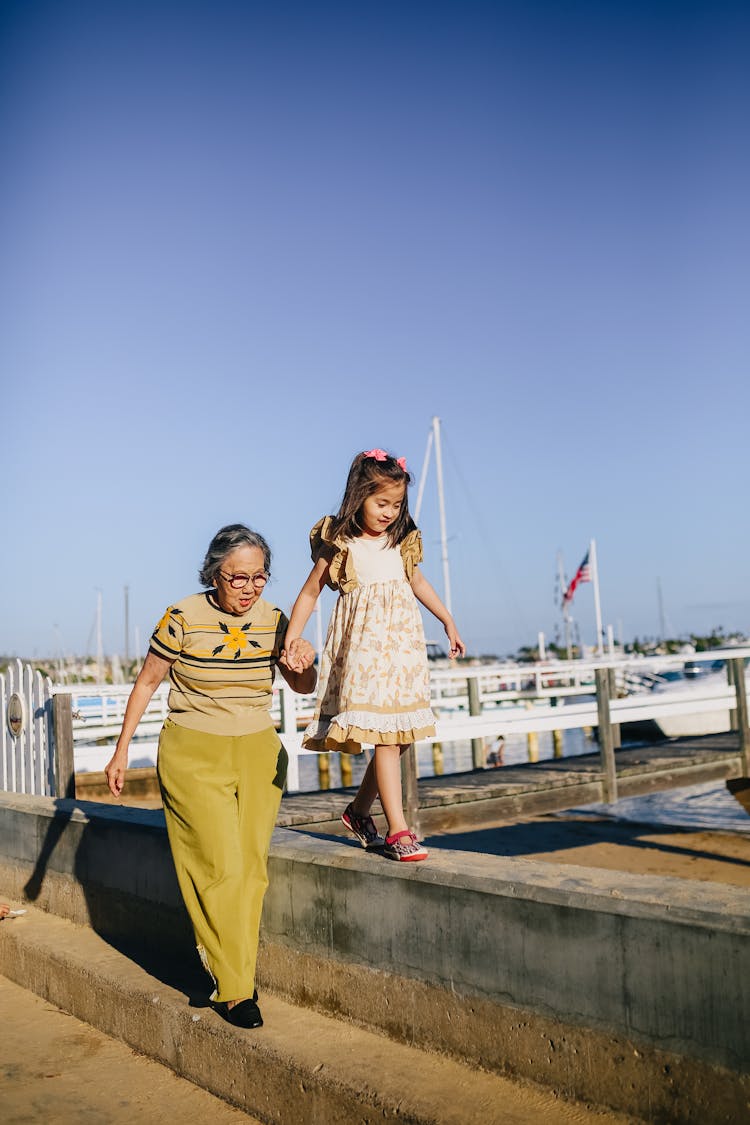 Grandma Holding Her Granddaughter While Walking