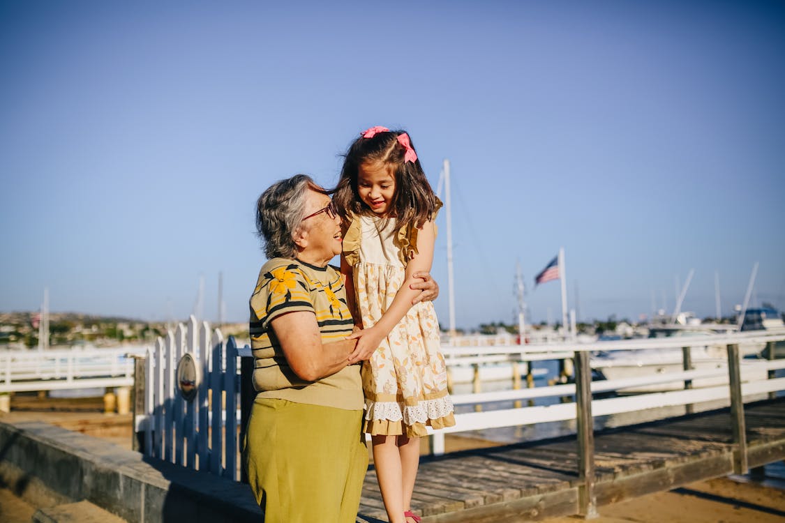 Grandma with Her Granddaughter Standing on the Shore