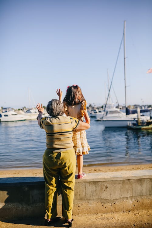 Grandma with Her Granddaughter Standing on the Shore