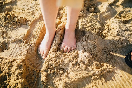 Child Standing on Brown Sand