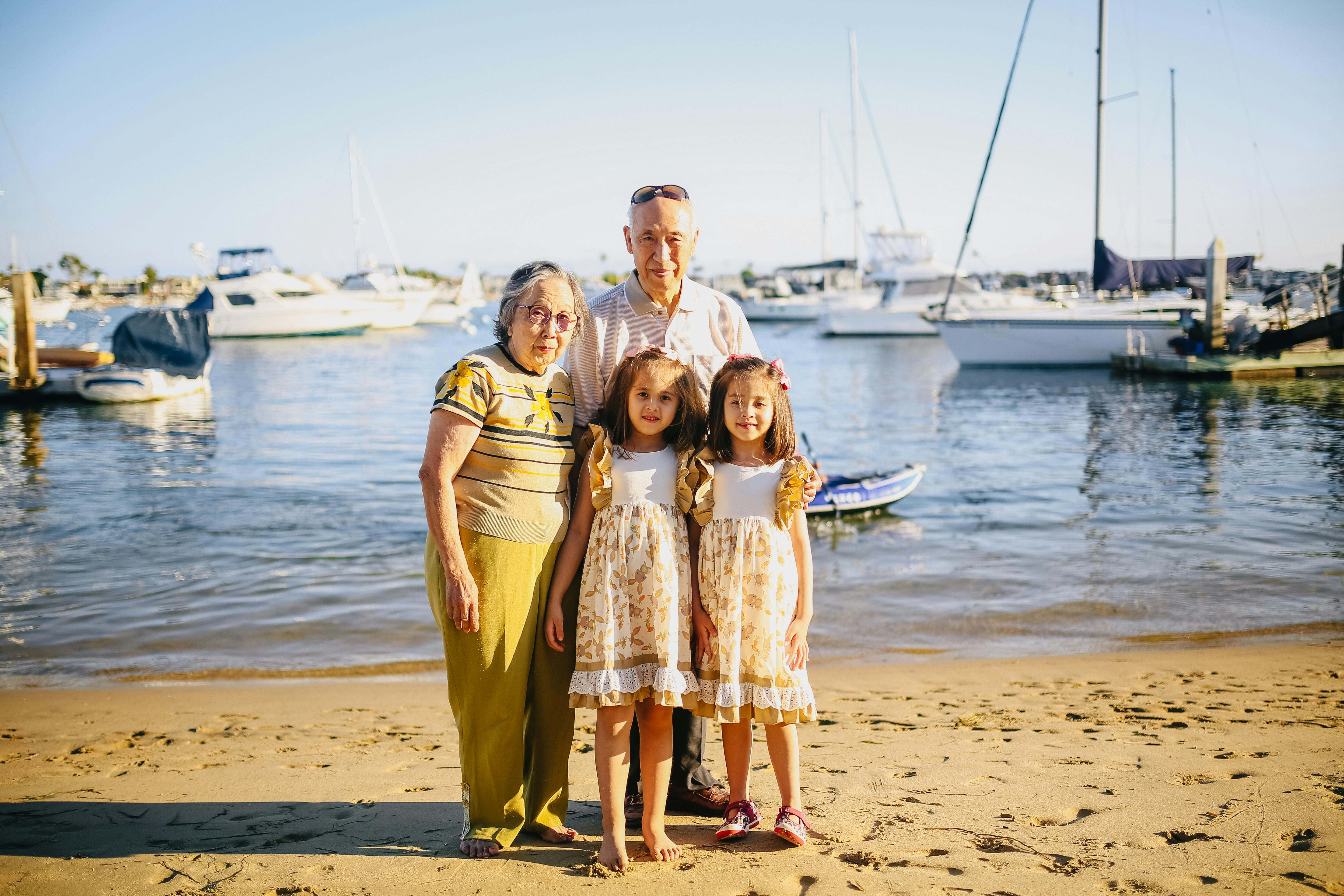 grandparents with their granddaughters standing by the shore