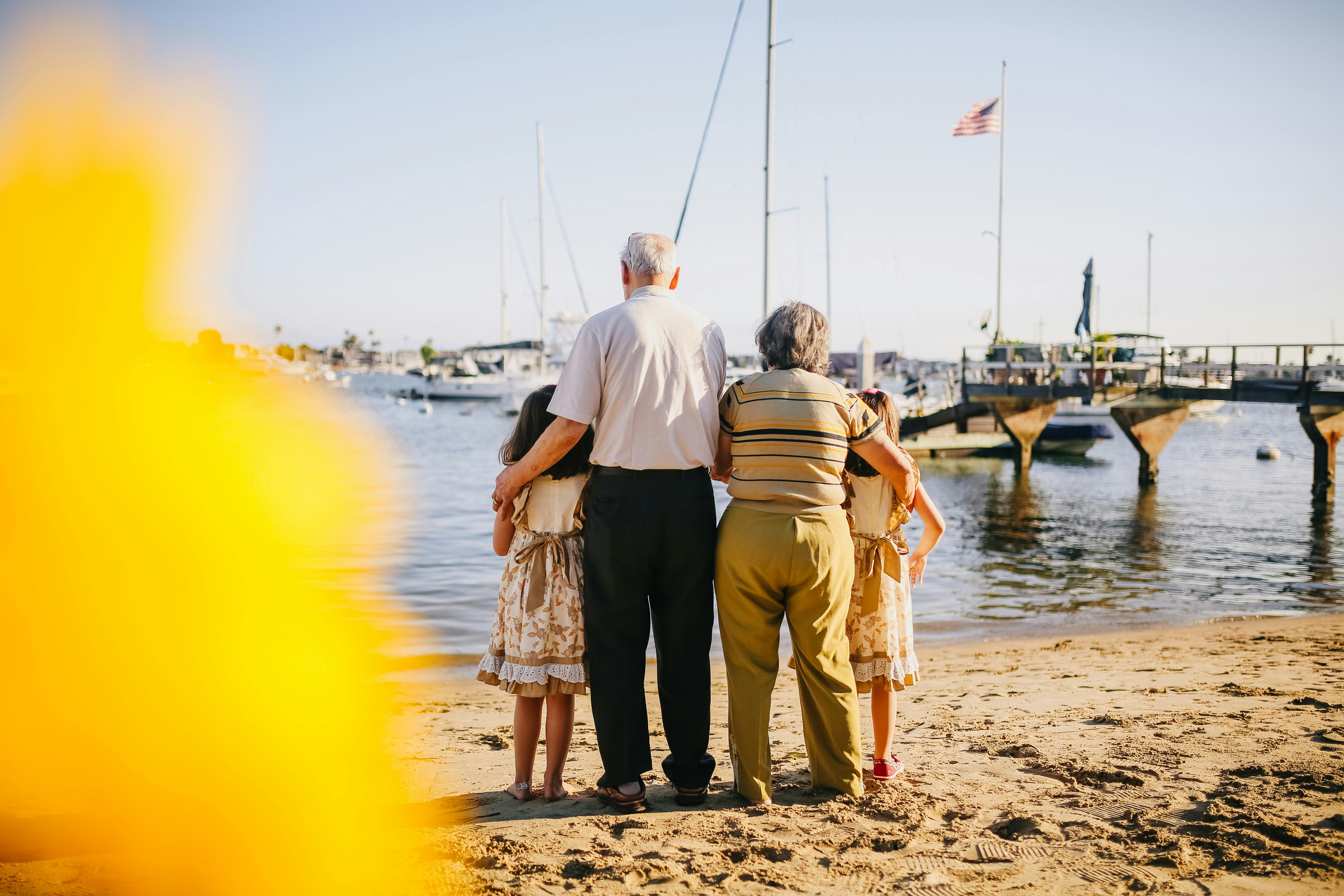 grandparents with their granddaughters standing by the shore