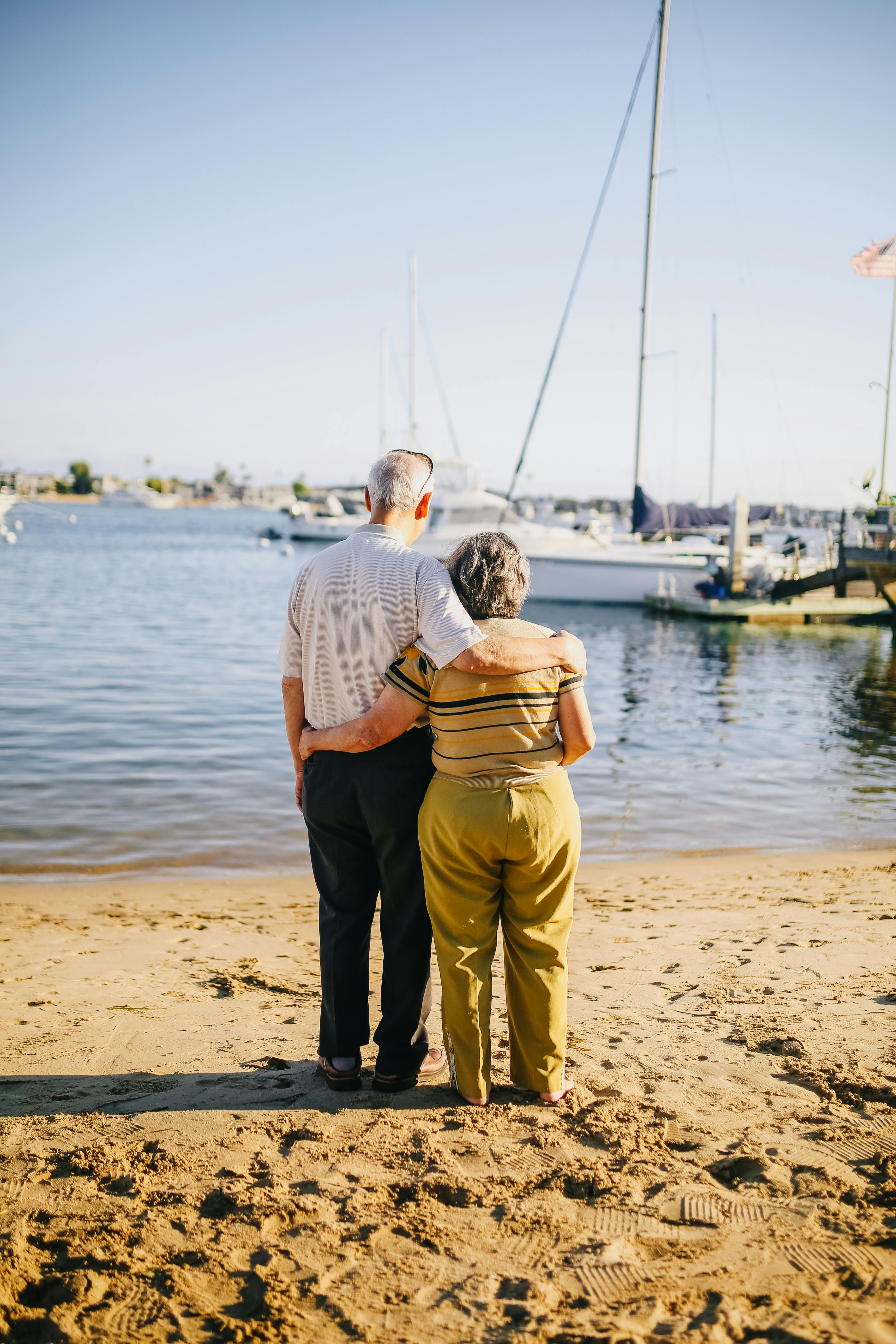 elderly couple standing on the shore