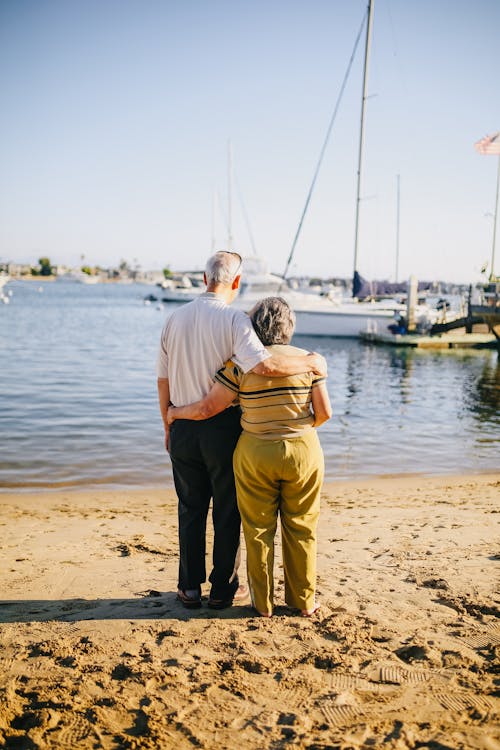 Free Elderly Couple Standing on the Shore Stock Photo