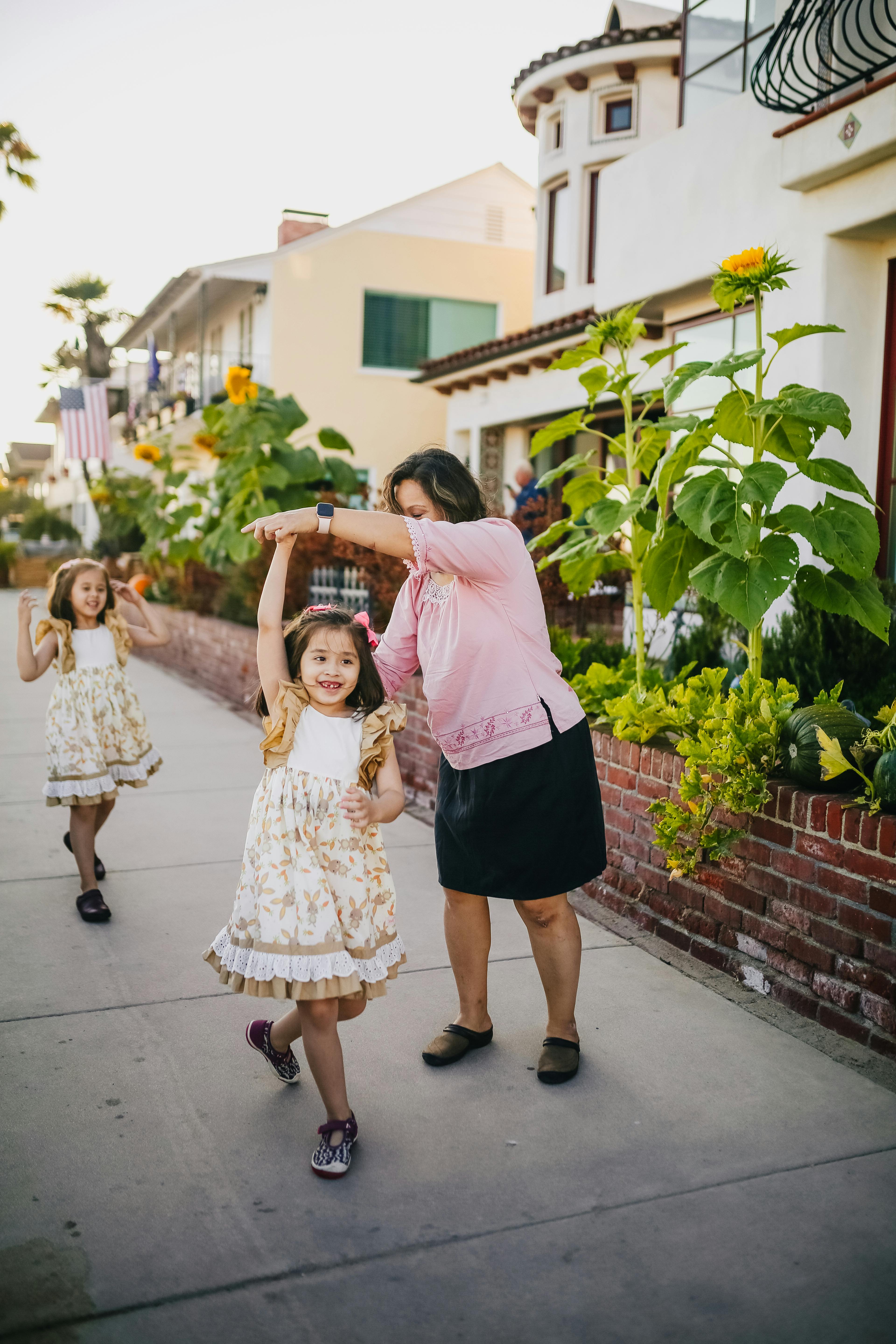 mother dancing with her daughters on the street