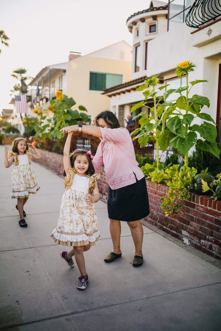 Mother Dancing With Her Daughters On The Street