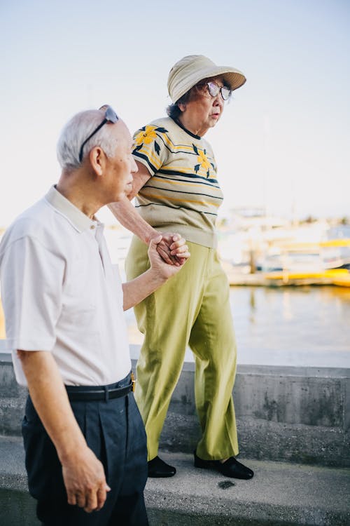 Free Elderly Couple Walking by the Bay Stock Photo