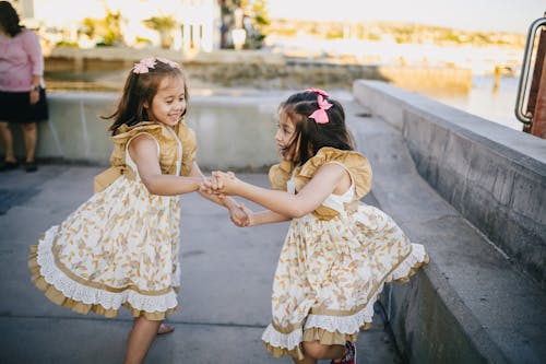 2 Meninas Em Vestido Floral Branco Dançando Na Rua