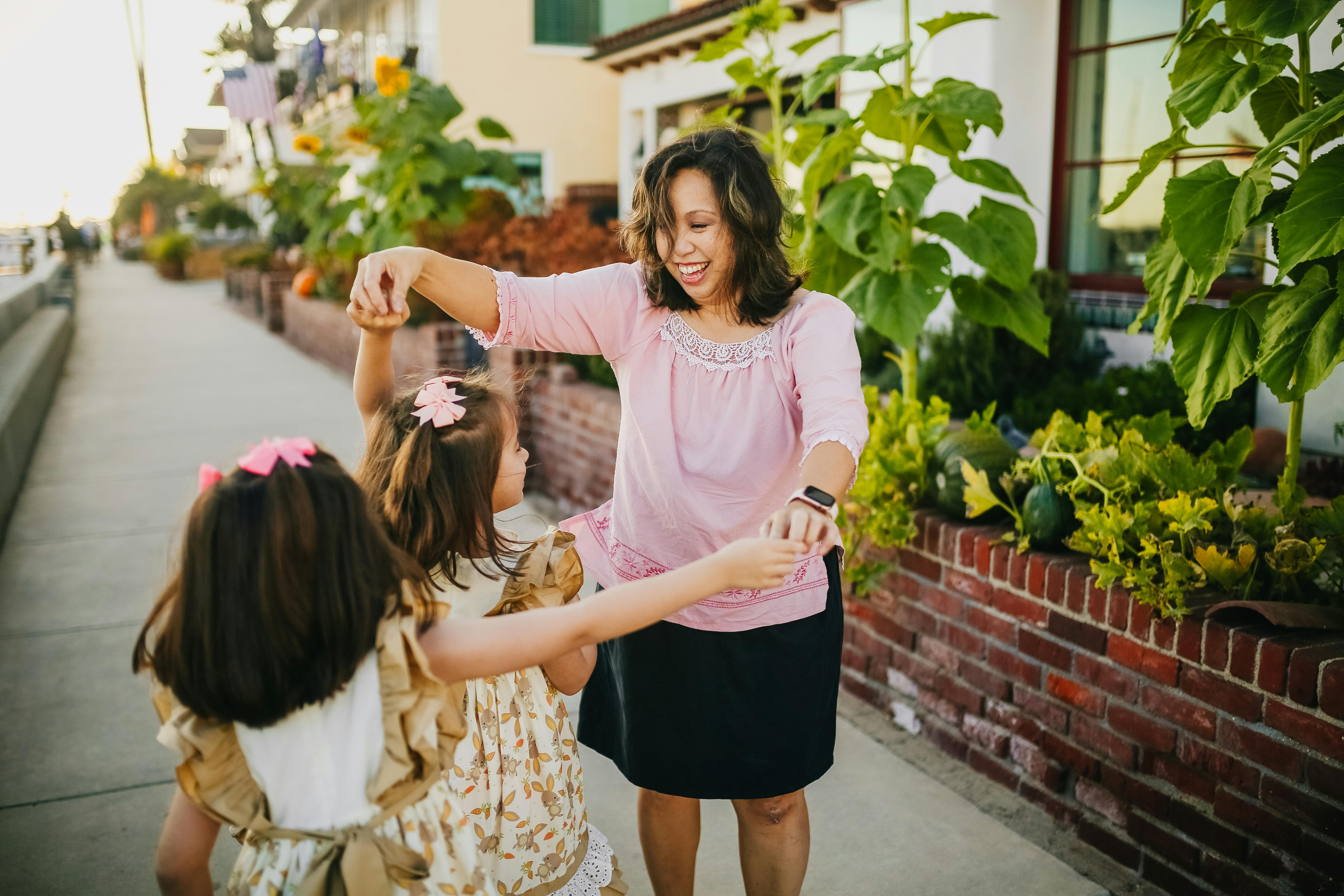 mother dancing with her daughters on the street