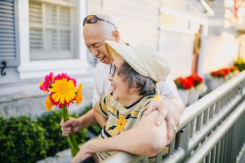 Elderly Man Giving Colorful Flowers to His Wife